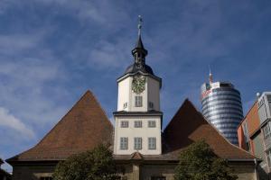 rotes Doppelwalmdach der Rathauses mit weißem Rathausturm vor blauem Himmelrum  