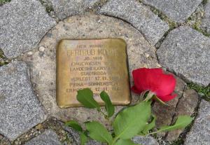 Stolperstein mit roter Rose