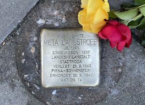 Stolperstein mit roter und gelber Rose