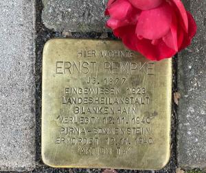 Stolperstein mit roter Rose