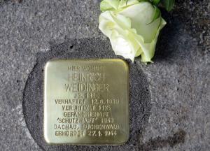 Stolperstein mit weißer Rose