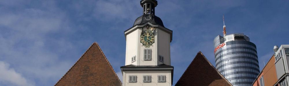 rotes Doppelwalmdach der Rathauses mit weißem Rathausturm vor blauem Himmelrum  